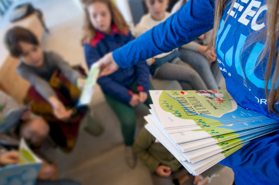 Educadora repartint informació del cicle de l'aigua